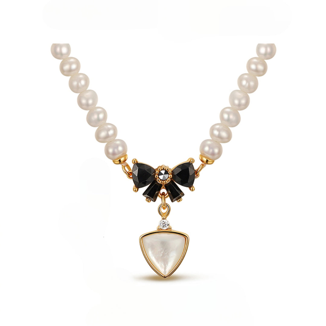 Elegant pearl necklace featuring a black bow centerpiece and a triangular pendant with a sparkling crystal.