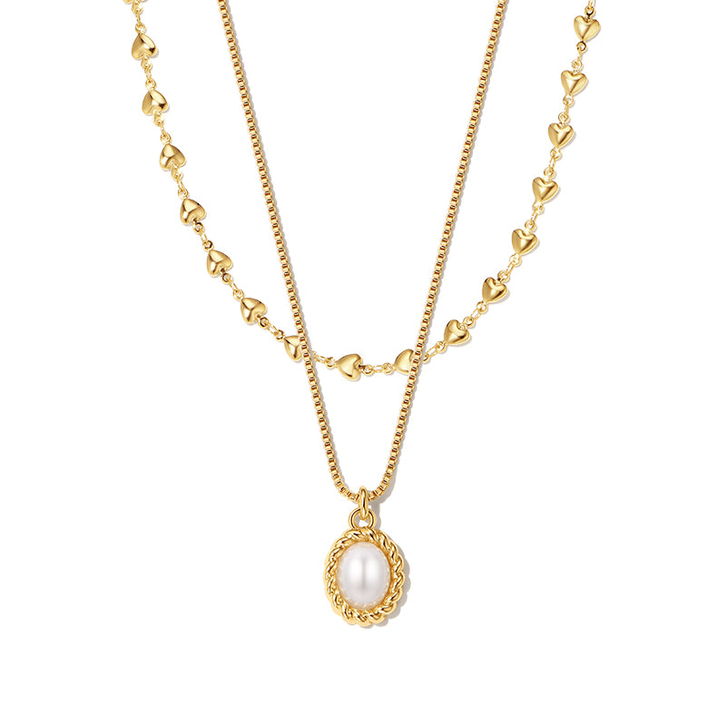 Gold layered necklaces featuring heart-shaped links and a central oval pearl pendant, exuding elegance and charm.